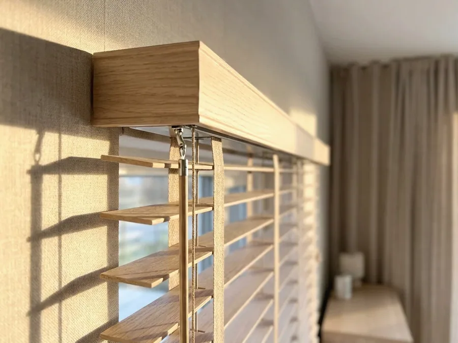 Close-up of a timber venetian headrail and tilt mechanism being serviced
