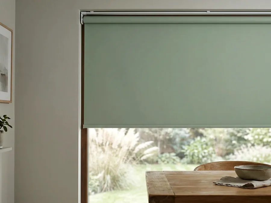 Smooth flat roller blind on its tube above a dining window in a Fourways home